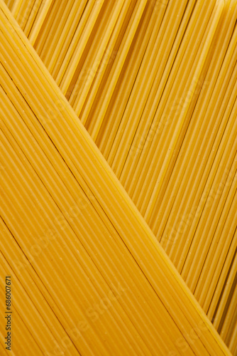 Abstract image of dry spaghetti pasta in diagonal lines, food bckground with space