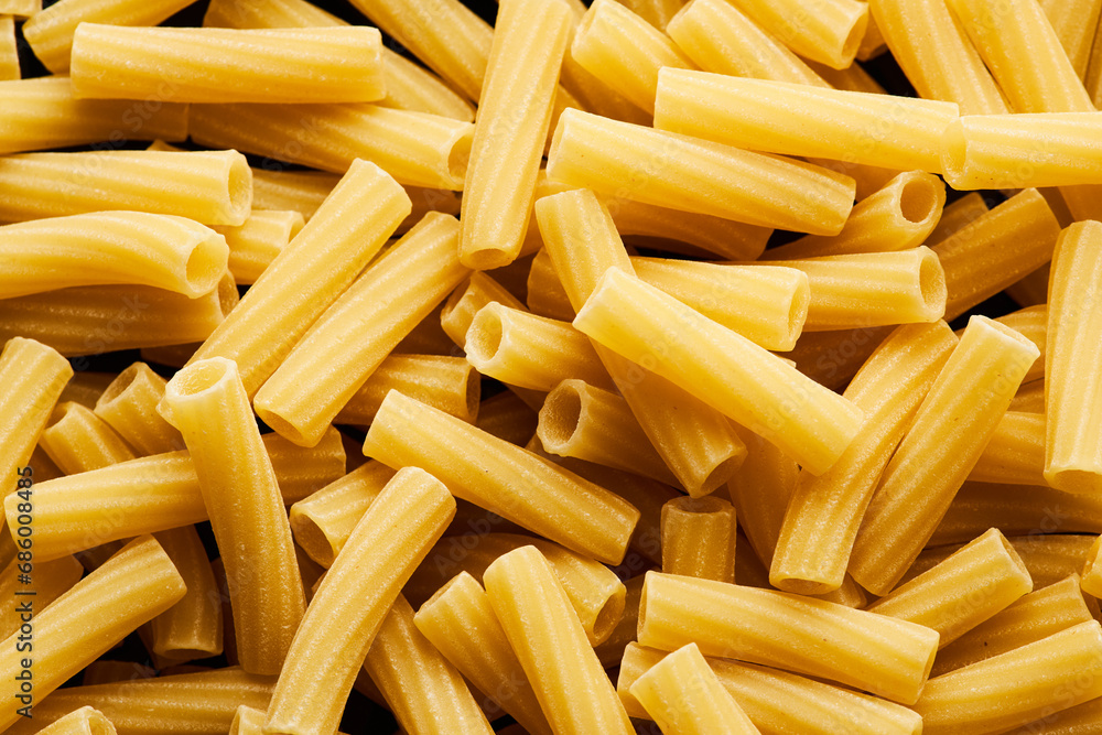 Top view macro food background of rigatoni pasta in heap, copy space Top view macro food background of rigatoni pasta in heap, copy space