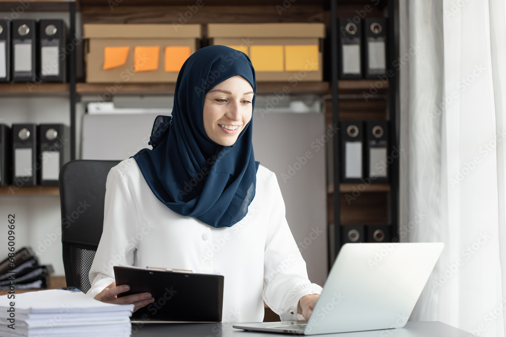 Happy muslim woman working at desk in office, Happy muslim woman working at desk in office,