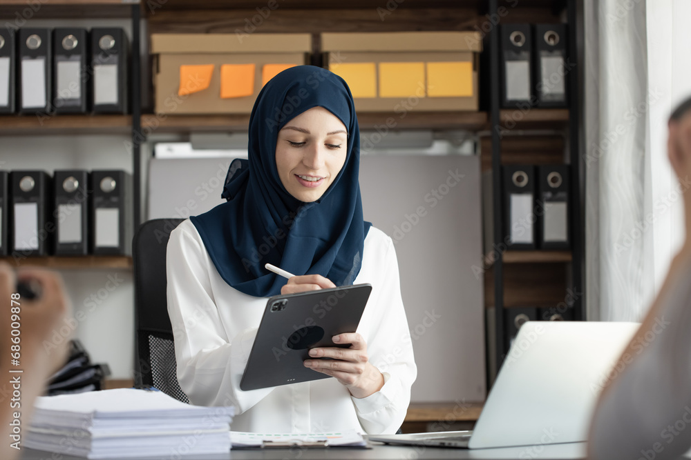 Happy muslim woman working at desk in office, Happy muslim woman working at desk in office,
