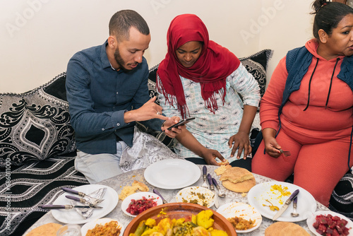 Ethnic people using smartphone while sitting at table