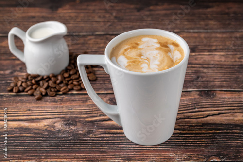 Relaxing latte coffee in white porcelain cup on wooden table