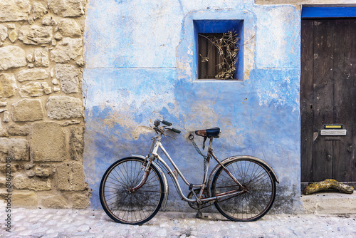 old bicycle in front of a blue wall