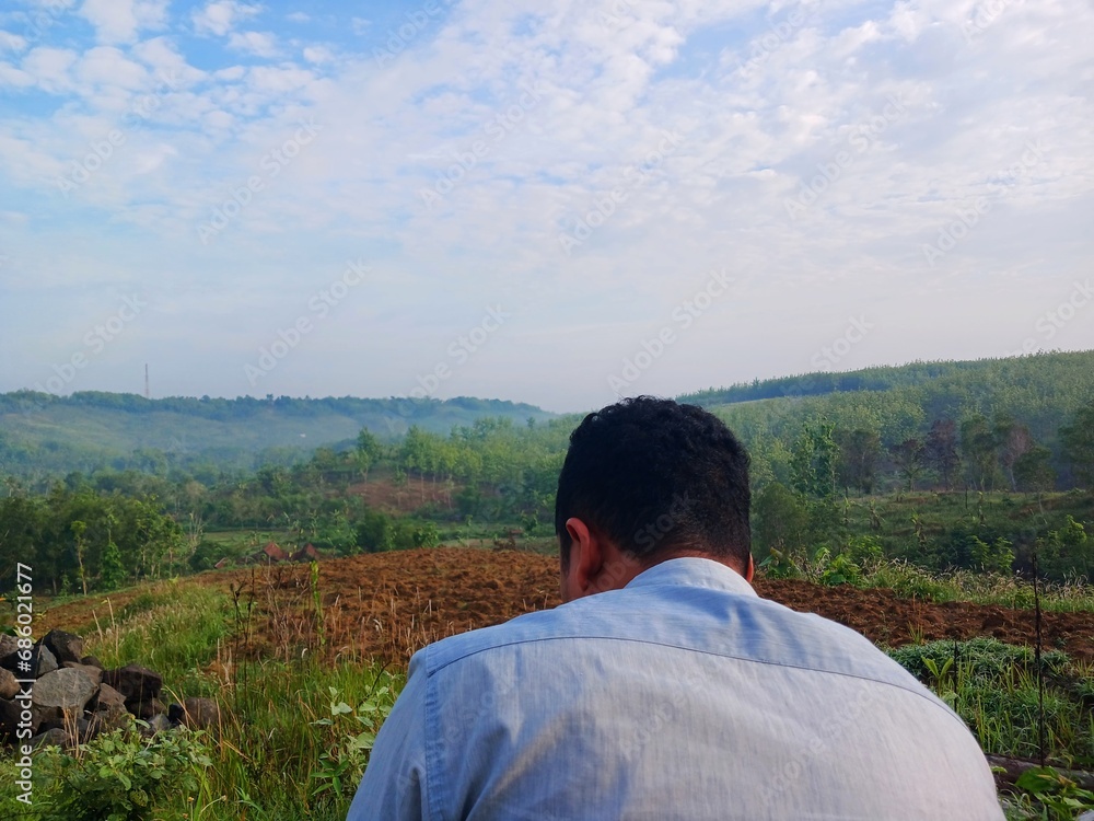 Man looking at view of hilly plantation. See the view of the hill. Man looking at view of hilly plantation. See the view of the hill.