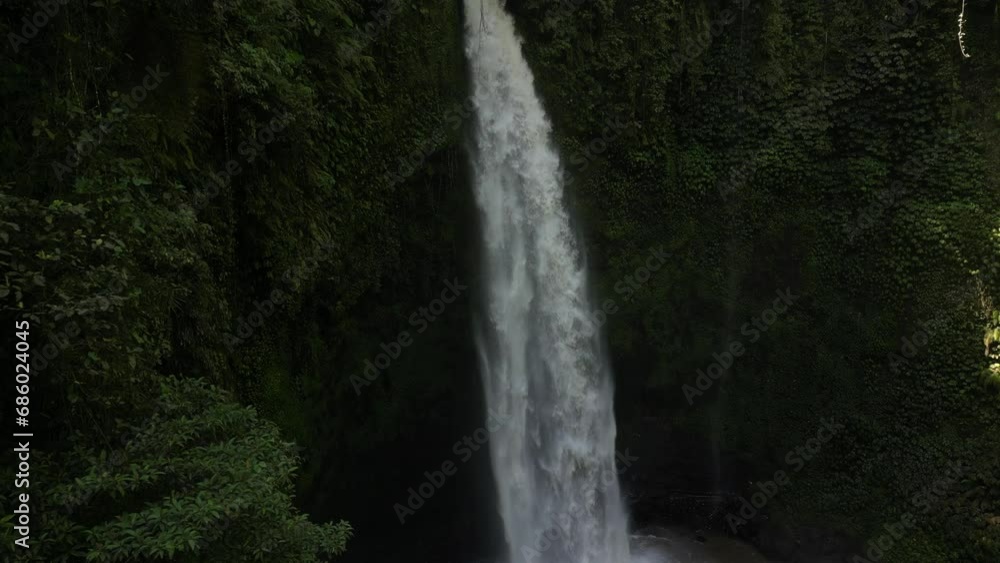 The power of Nungnung waterfall on a sunny afternoon in Bali, Indonesia. Aerial. The power of Nungnung waterfall on a sunny afternoon in Bali, Indonesia. Aerial.