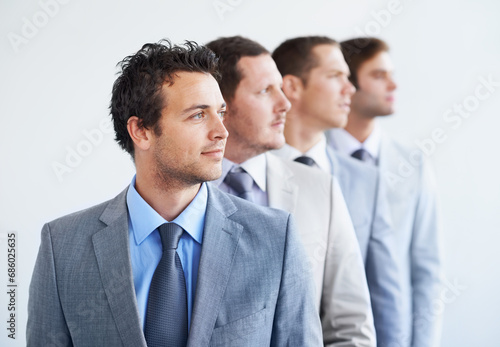 Men, thinking and serious for job interview, hiring selection and ready for finance career. Worker, corporate accountant in suit and professional in workplace, people in background and confident