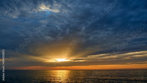 The rays of the sun shine through the clouds. Colorful cloudy sky at sunset. Gradient color. Sky texture  abstract nature background. Positive photography.