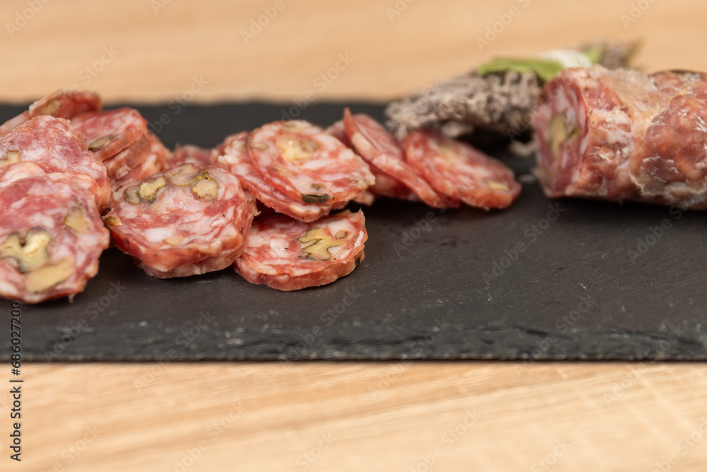 Chorizo ​​sausage and salami, delicate cut. spanish salami on black background with spices, paprika, pepper. Spicy food. red pepper.
