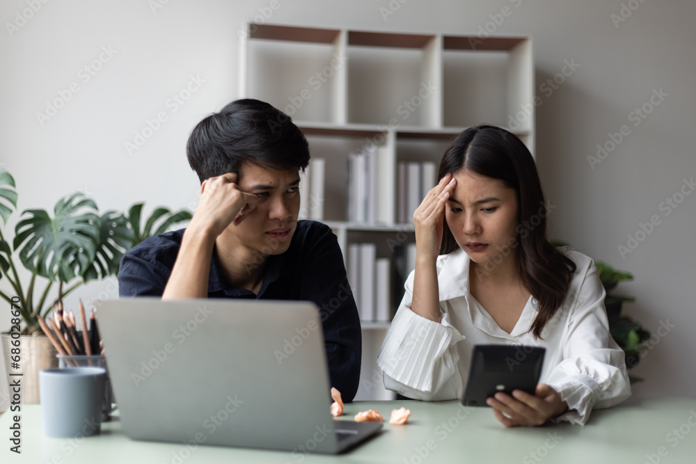 Two young asian businessman and woman are sitting stressed out with work in the office. Two young asian businessman and woman are sitting stressed out with work in the office.
