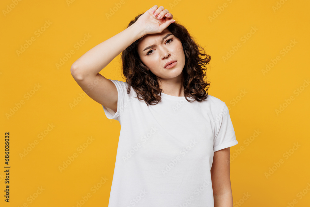 Young sad sick tired exhausted Caucasian woman wear white blank t-shirt casual clothes put hand on forehead look camera isolated on plain yellow orange background studio portrait. Lifestyle concept. - obrazy, fototapety, plakaty 