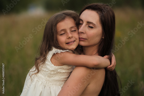A girl's elated expression as she hugs her mom near the woods. Against screen addiction, nature offers genuine moments. © yavdat