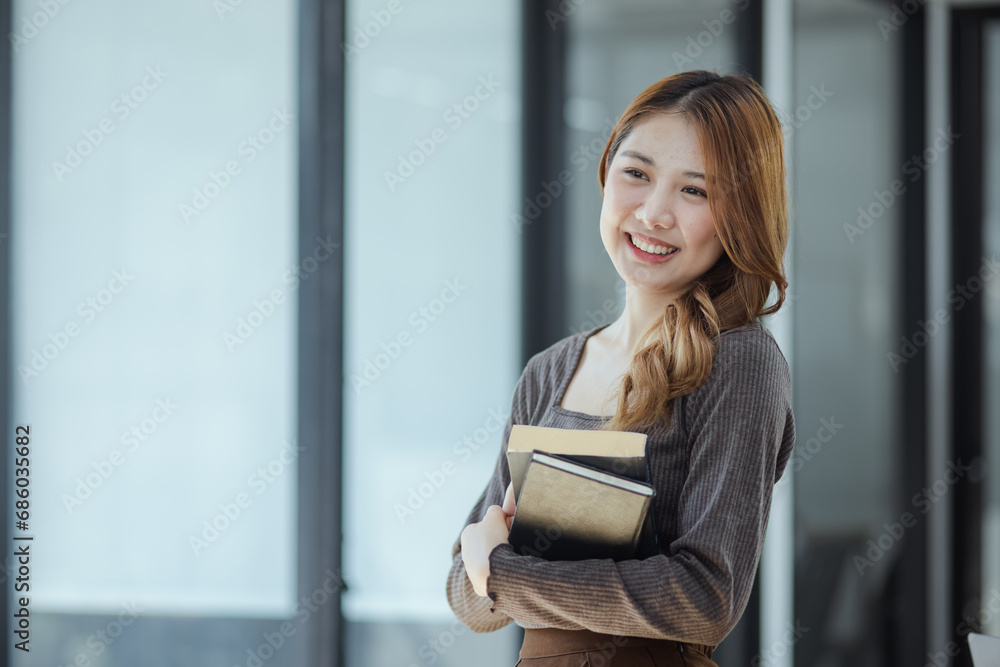 young asian woman holding a book in hands and education, lifestyle of woman studying. 