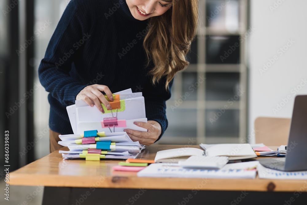 Asian businesswoman working with stack of documents papers at office desk. Asian businesswoman working with stack of documents papers at office desk.