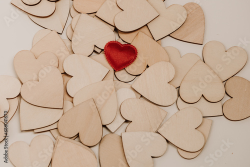 Red heart on wooden hearts background,background with wooden hearts and one red one,background with wooden hearts and one red one