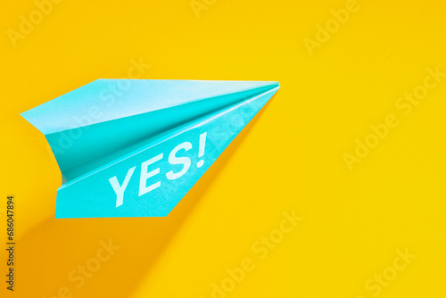 Free Download Paper plane and YES tmessage concept. Design with blue airplane on yellow background. - GFXLoad