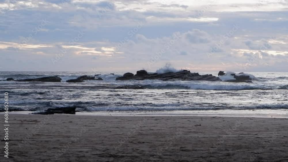 Calm ocean waves crash onto sand beach rocks on Nicaragua coast Calm ocean waves crash onto sand beach rocks on Nicaragua coast