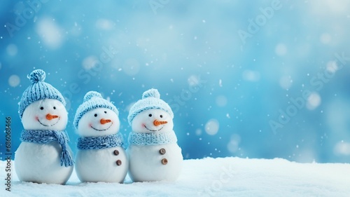 Little knitted snowmans on soft snow on blue background, copy space and generative ai © Nia™