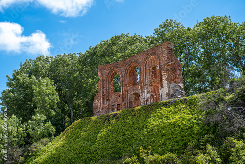 The photograph shows sunken fragments of the Church of St. Nicholas in Trzęsacz, which are a symbolic historical souvenir in contrast with the Baltic coast.