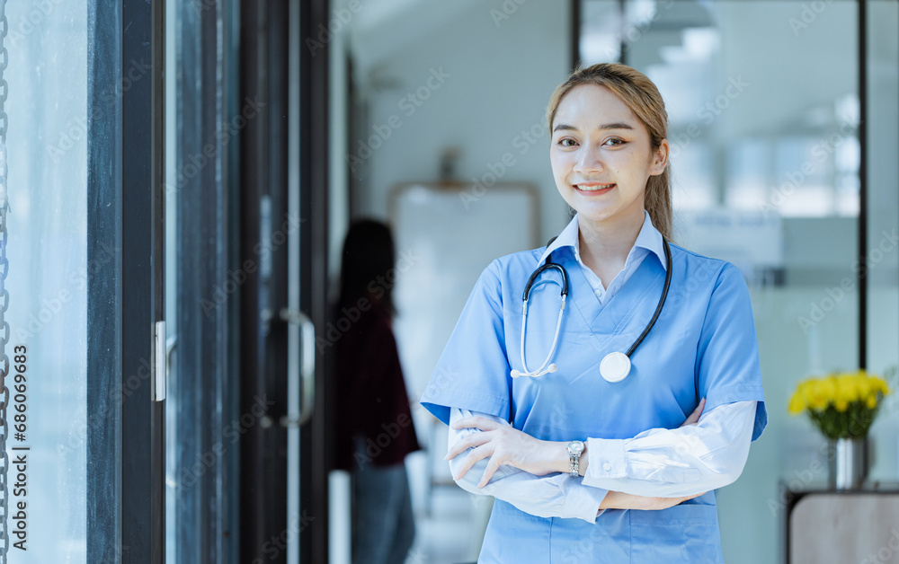 © SOMKID - Asian female doctor Standing with arms crossed at hospital, Medicine and healthcare concept.