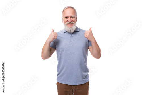 portrait of a gray-haired mature man with a beard and mustache in a t-shirt and trousers on a white background