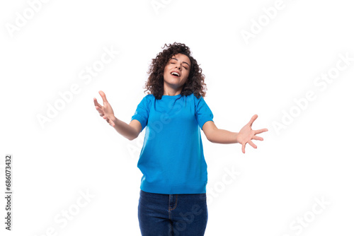 cute young curly brunette woman with shoulder-length hair dressed in a blue t-shirt stretches out her arms for a hug