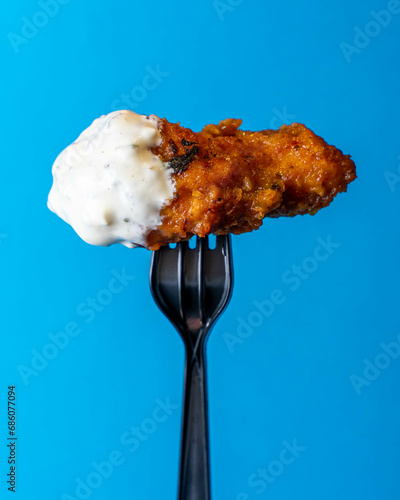 Fried Chicken Hot Wing Being Held Up On  A Fork Dipped In Cool Ranch Sauce, Royal Blue Background, Editorial Creative Food Photography 