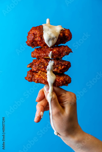 Fried Chicken Hot Wing Being Dipping With Cool Ranch Sauce, Royal Blue Background, Editorial Creative Food Photography 