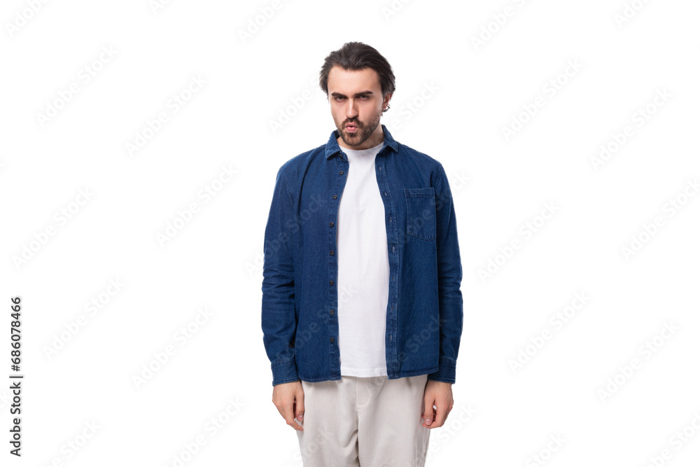 young european brunette man with a cool hairstyle is dressed in a blue denim shirt over a t-shirt young european brunette man with a cool hairstyle is dressed in a blue denim shirt over a t-shirt