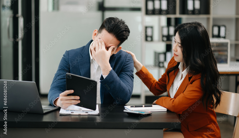 Fototapeta premium Furious two Asian businesspeople arguing strongly after making a mistake at work .