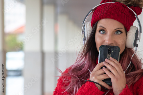 young woman with headphones on the street in winter