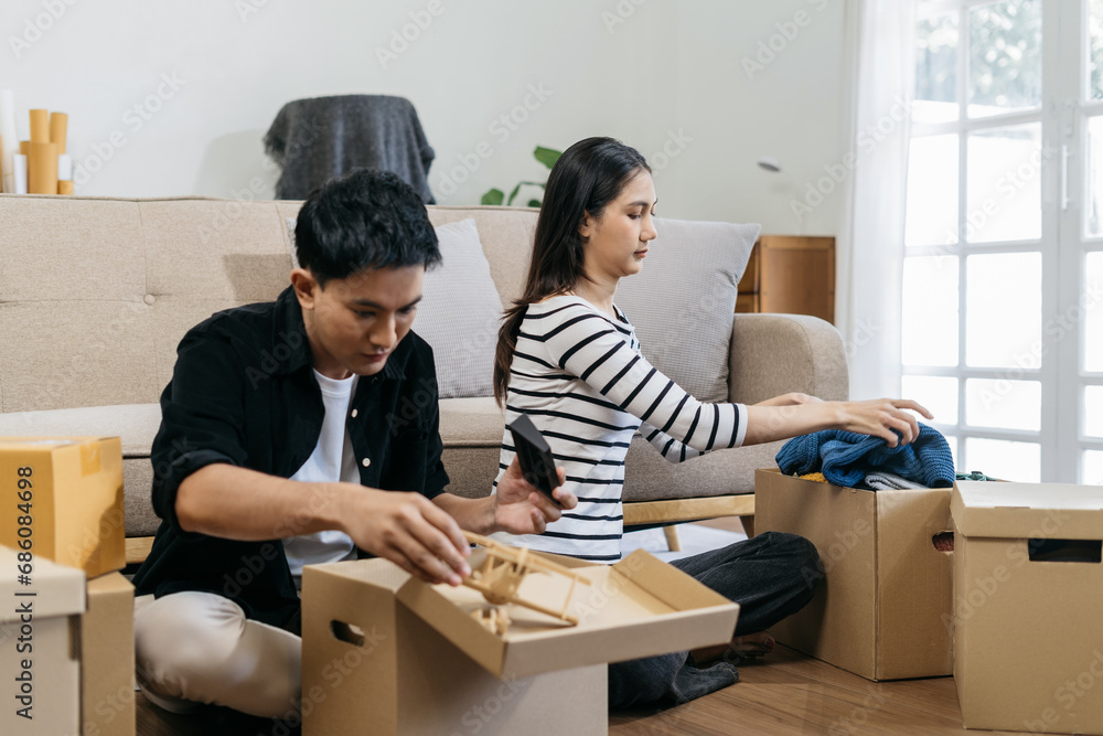 Young couple relaxing sitting on the floor around cardboard boxes at home, smiling happy moving to a new house. Young couple relaxing sitting on the floor around cardboard boxes at home, smiling happy moving to a new house.