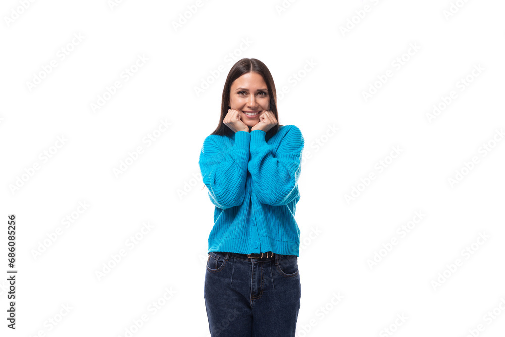 young pleasantly surprised pretty european brunette woman dressed in a blue button-down sweater rejoices on a white background with copy space young pleasantly surprised pretty european brunette woman dressed in a blue button-down sweater rejoices on a white background with copy space