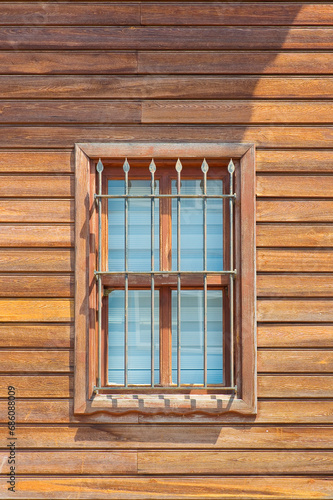Old traditional wooden window with wall made of wooden slats