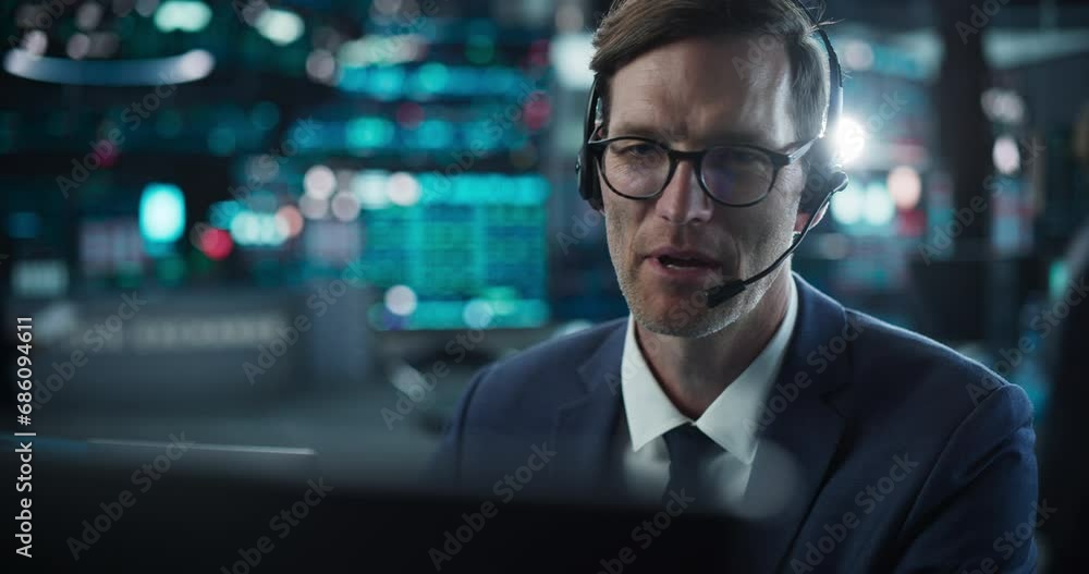 Close Up Portrait of a Smart and Thoughtful Stock Exchange Broker. Adult Man in Glasses Looking at Computer Screen, Communicating with a Client on a Phone Call, Talking About Investing Strategy Close Up Portrait of a Smart and Thoughtful Stock Exchange Broker. Adult Man in Glasses Looking at Computer Screen, Communicating with a Client on a Phone Call, Talking About Investing Strategy