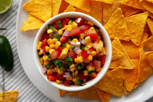 Homemade Corn Salsa with Tortilla Chips on a Plate, top view. Overhead, from above, flat lay. Close-up.