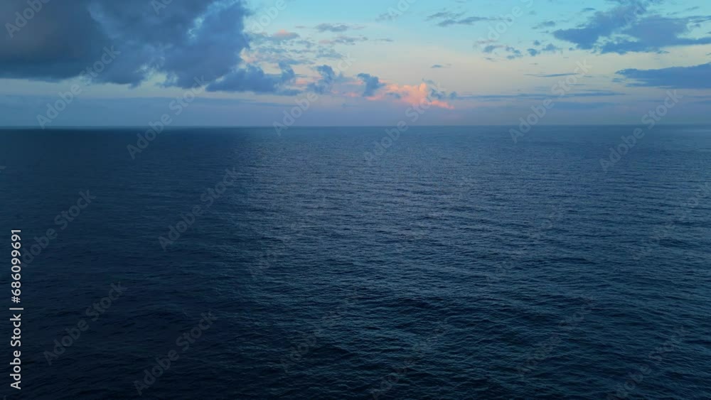 Calm ocean water spreads out to horizon with an empty Caribbean sunset over sea Calm ocean water spreads out to horizon with an empty Caribbean sunset over sea