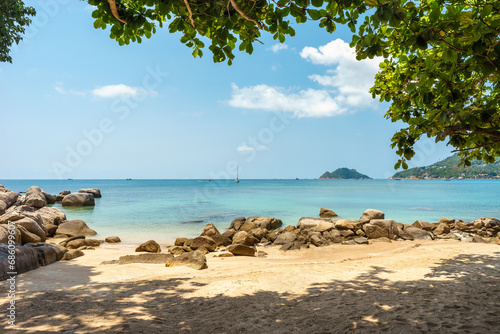 Fototapeta Naklejka Na Ścianę i Meble -  Picturesque seascape view of tropical sandy Sairee beach, calm sea turquoise horizon and shade branches of tree and rocks on shore on Koh Tao island in Thailand