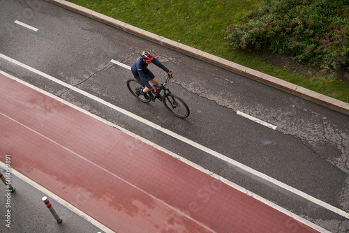 Man riding on bicycle on a bike path in the city. View from above.