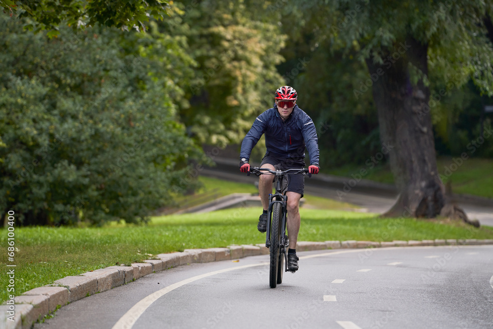 Fototapeta premium Man riding on bicycle on a bike path in the city.