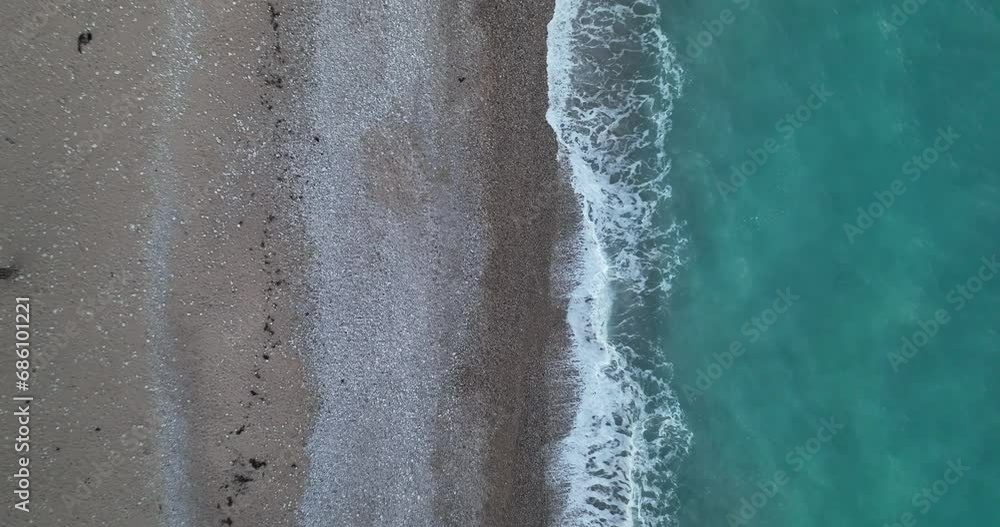 Vista cenital de una playa con olas y arena de colores Vista cenital de una playa con olas y arena de colores