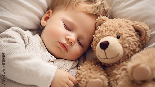 Sweet baby boy sleeping in bed with teddy bear stuffed toys