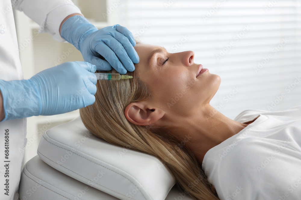 Trichologist giving injection to patient in clinic, closeup Trichologist giving injection to patient in clinic, closeup