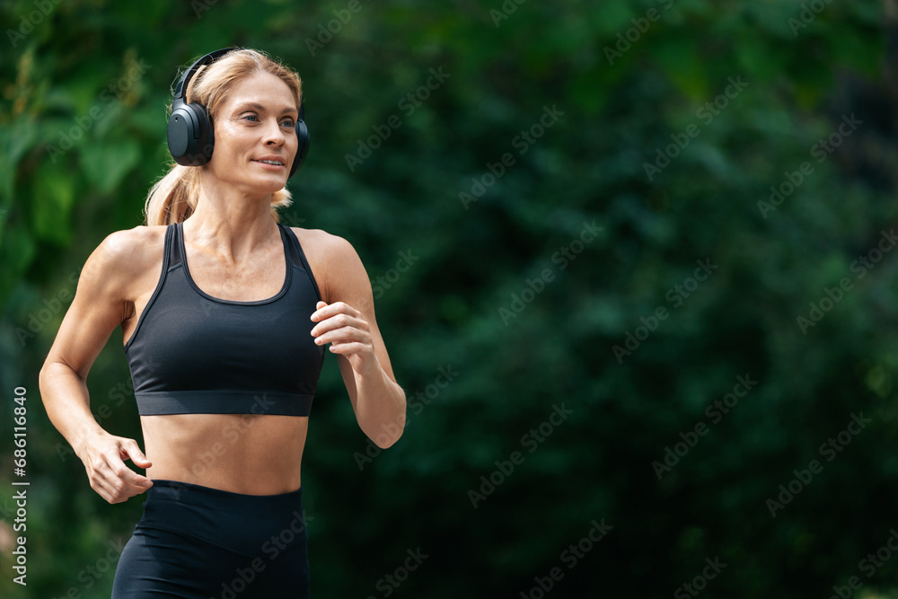 Sporty blonde runner woman running in park. Sporty blonde runner woman running in park.