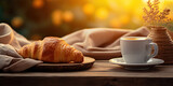 Cozy morning scene featuring a warm cup of coffee and fresh croissants bathed in the golden sunrise