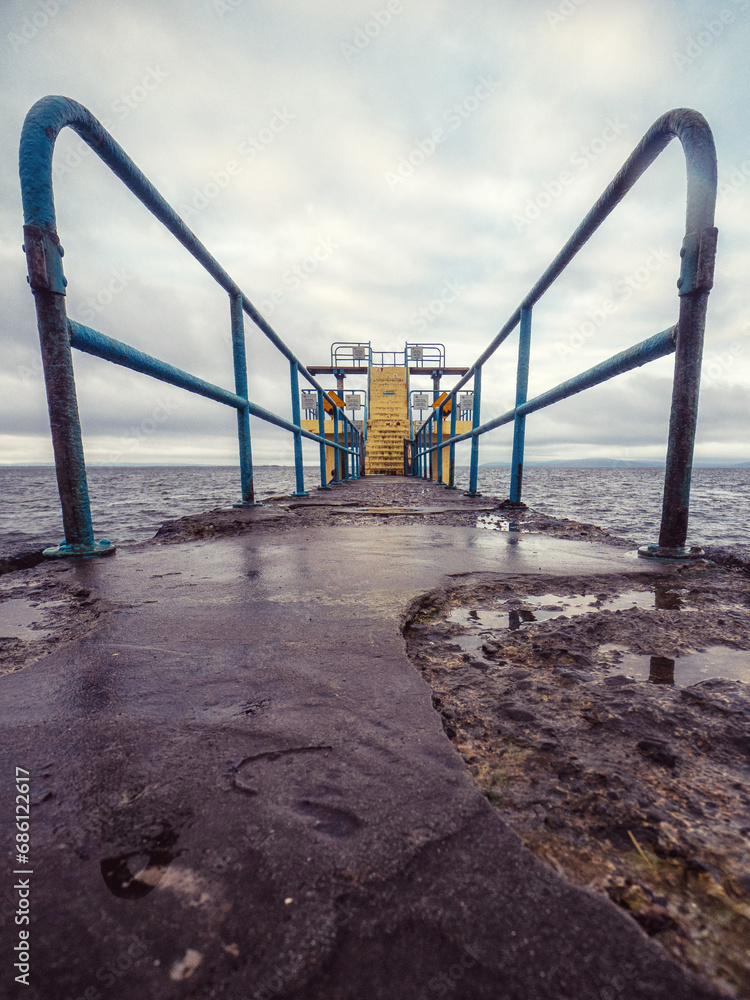 Famous Blackrock diving board in Salthill area of Galway city, Ireland. Cloudy sky over the ocean. Town landmark and tourist viewpoint with stunning Irish nature scenery. Vertical image Famous Blackrock diving board in Salthill area of Galway city, Ireland. Cloudy sky over the ocean. Town landmark and tourist viewpoint with stunning Irish nature scenery. Vertical image