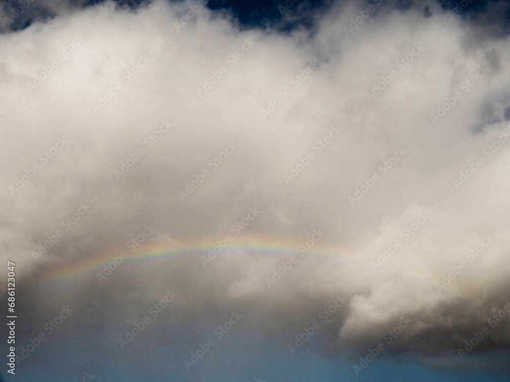 Cloudy sky with a rainbow. Nature background for design and replacement. Cloudy sky with a rainbow. Nature background for design and replacement.