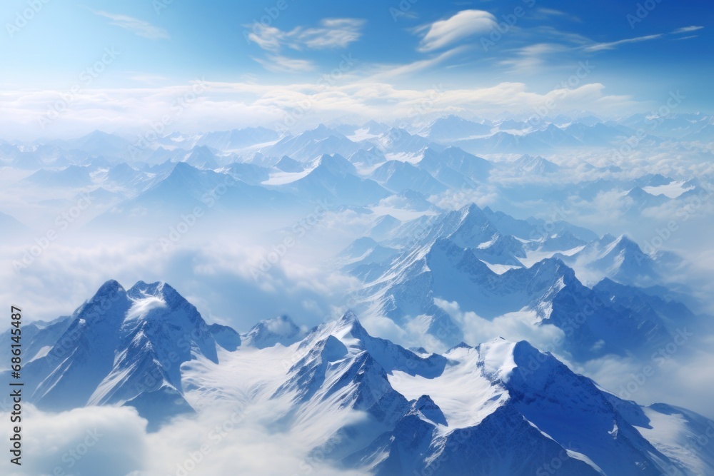  a view of the top of a mountain range from an airplane in the sky with clouds and blue sky in the background.