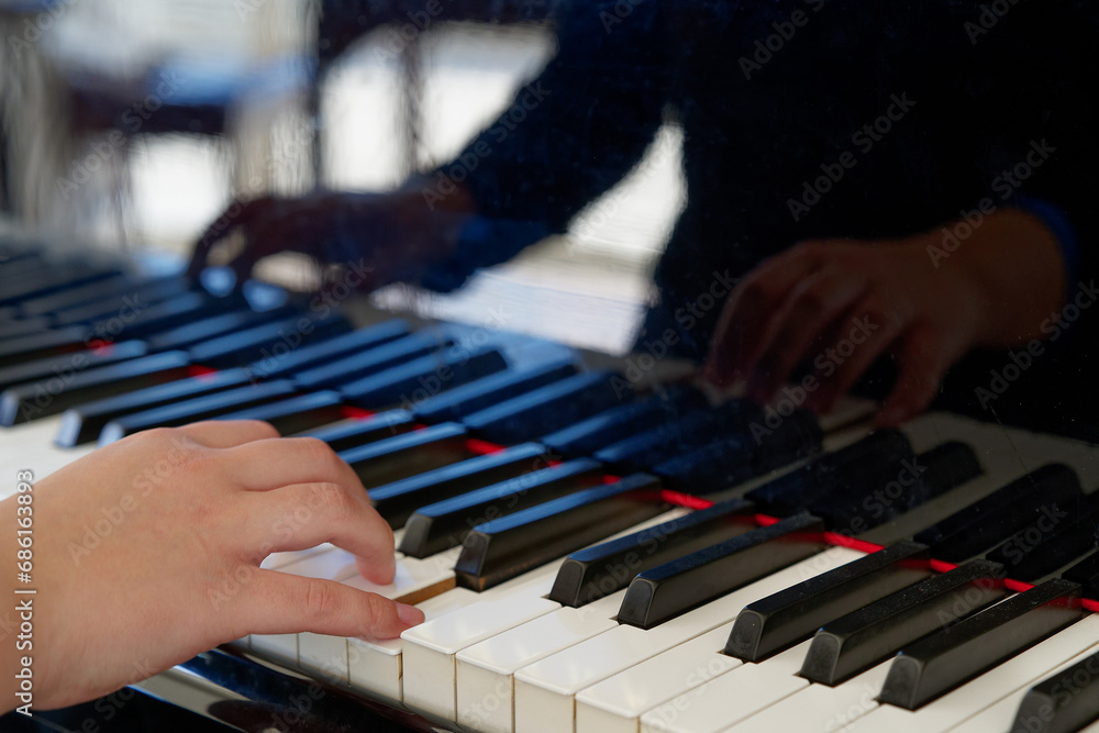 Obraz premium teenager hand on piano keys close-up