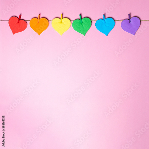 Hearts border with LGBTQ rainbow colors on pink background, diversity concept for Valentine day. Handmade, Paper craft.