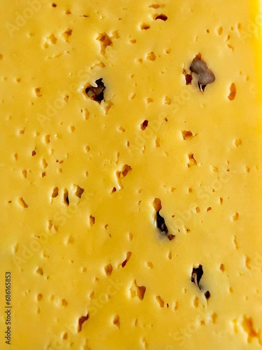 Texture of sliced ​​cheese for background. Cheese surface as background. Close-up of organic gourmet cheese with walnuts